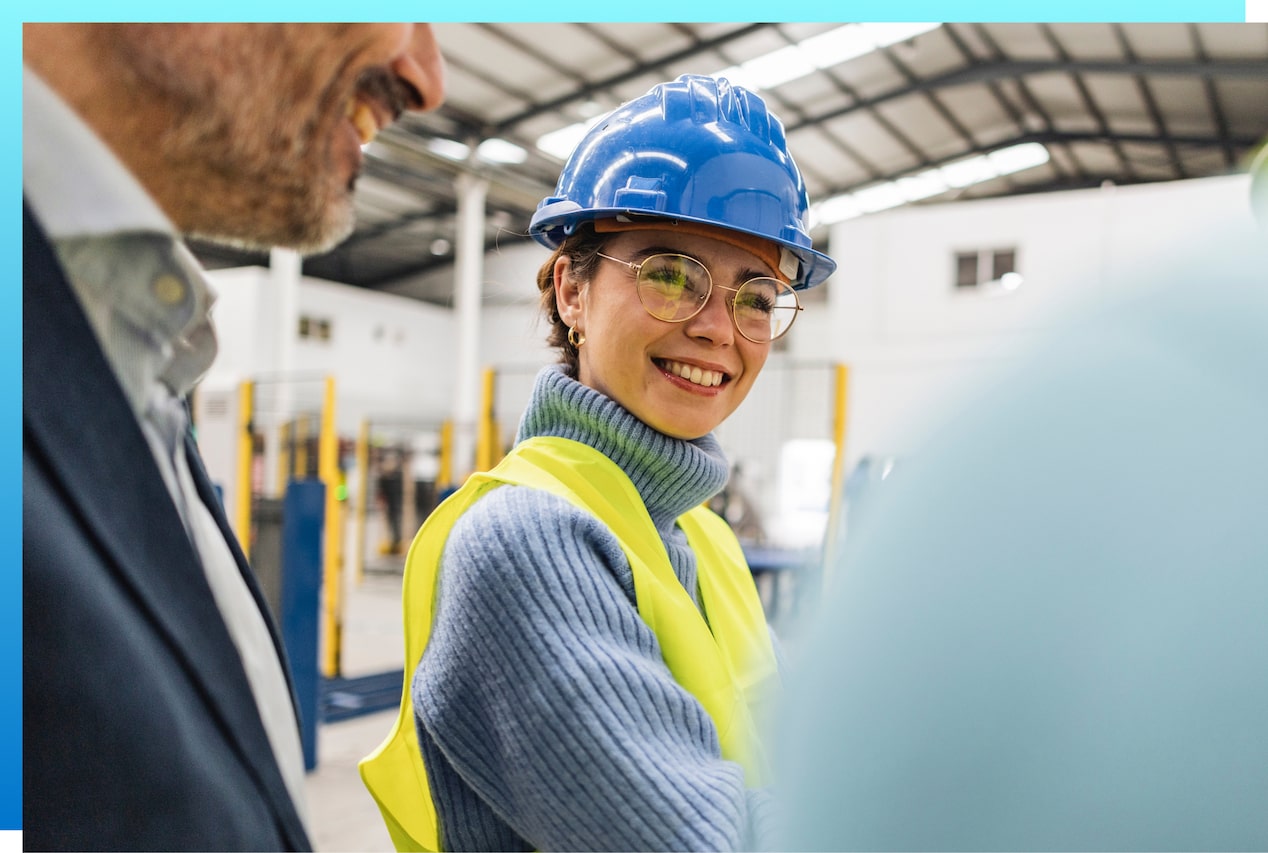 Man and woman in safety vest and safety glasses smiling