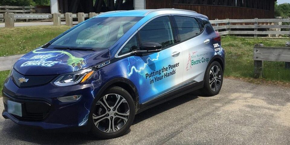 Electric New Hampshire Electric Cooperative branded car parked in a parking spot outside during the day