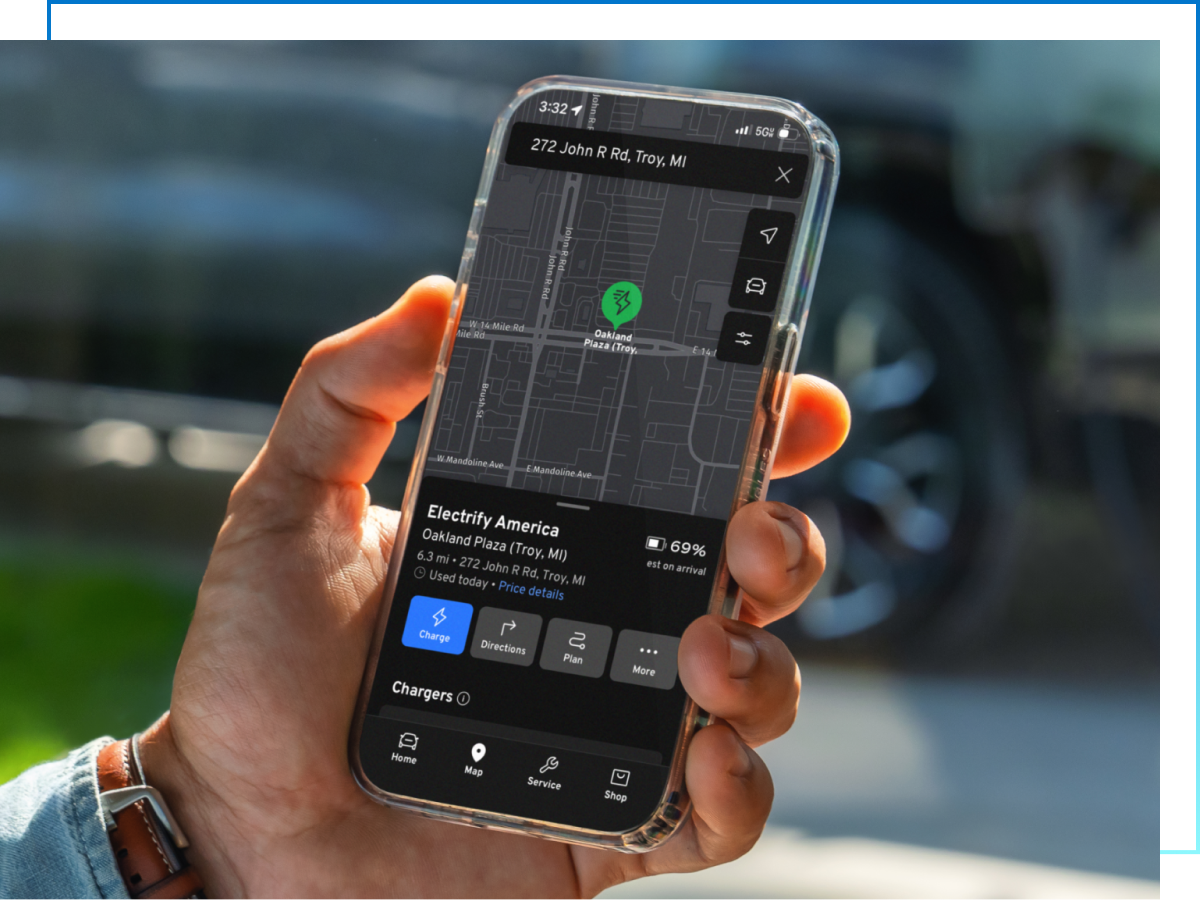 Hand holds phone showing charging station map with nearby location pulled up