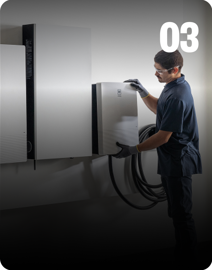 Installer installing GM Energy equipment on exterior wall