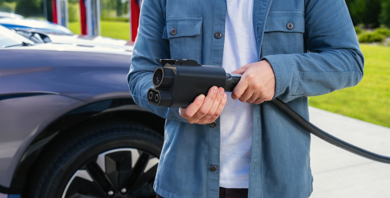 Man holding the NACS DC Adapter