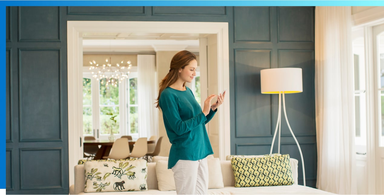 Woman standing in room looking at smartphone