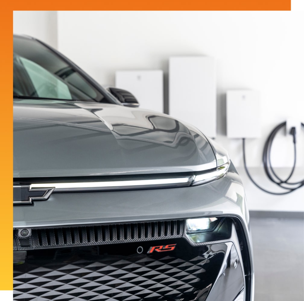 Grey Chevy EV in garage next to wall charging station