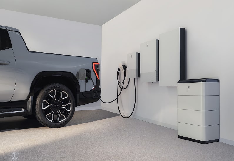 Grey Chevy EV in garage next to wall charging station