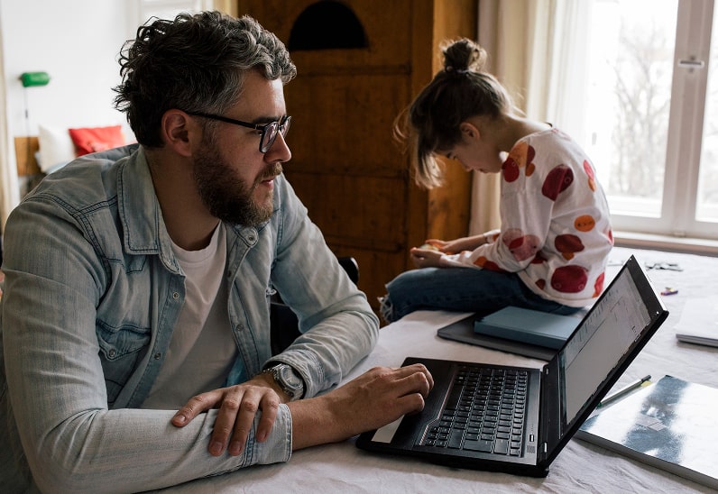 Man on Computer Next to Girl