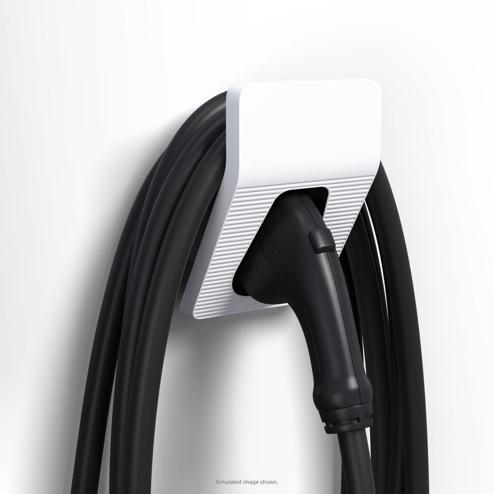White EV charger resting on wall station