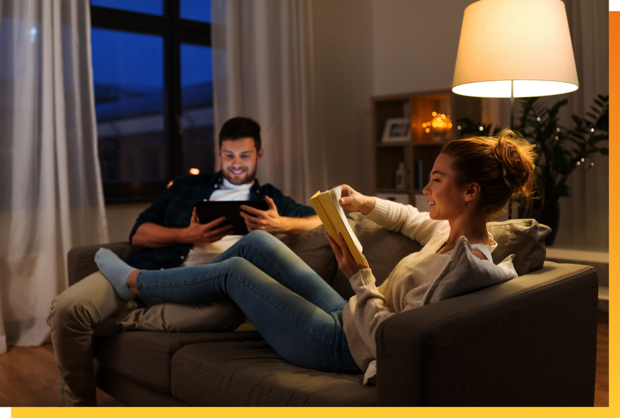 Man and woman sitting on couch reading