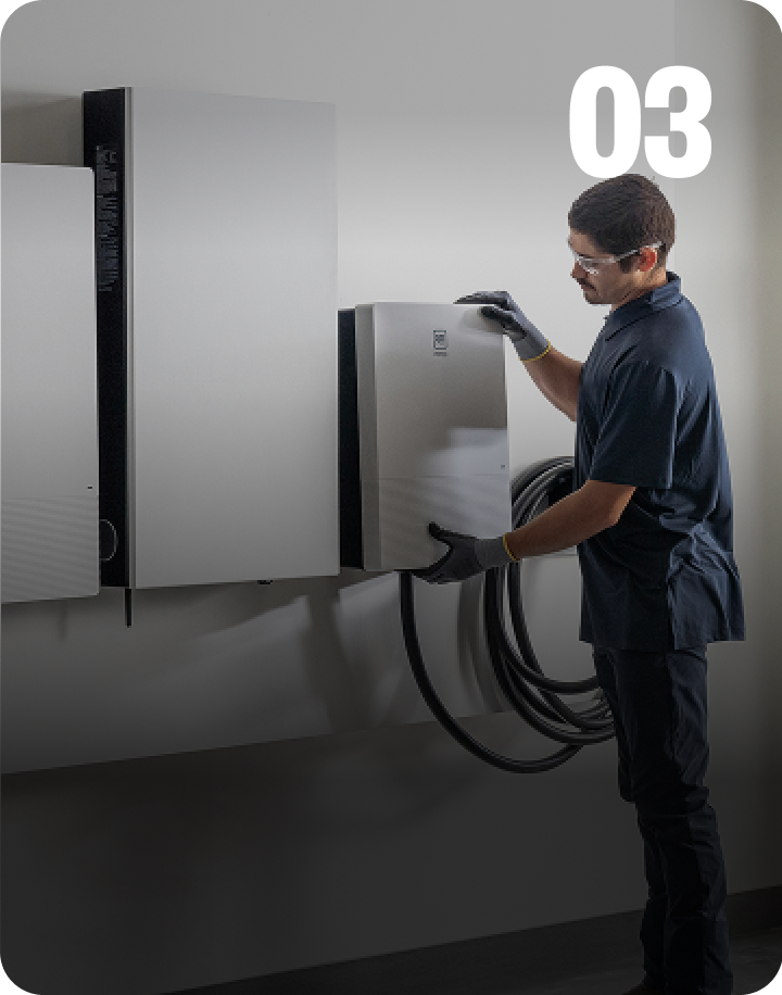 Installer installing GM Energy equipment on exterior wall