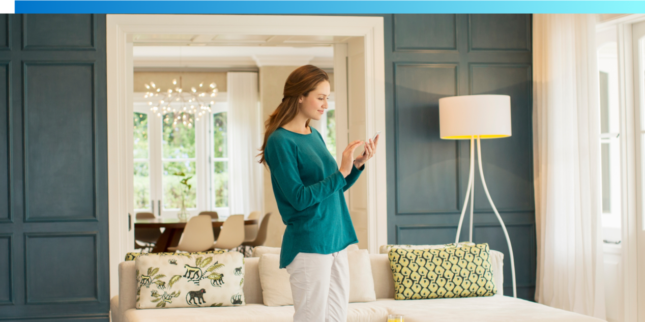 Woman standing in room looking at smartphone