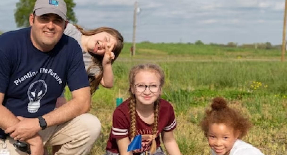 A man and kids planting a tree